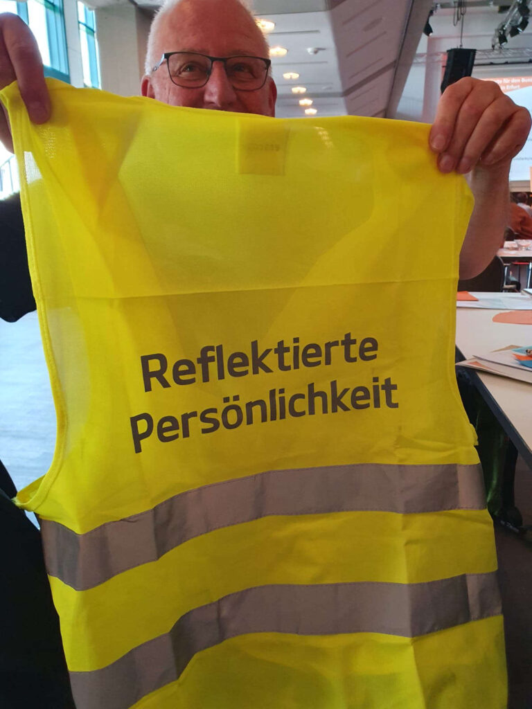 Foto Diözesanversammlung Diözesanverband Kolping Köln, kleiner scherz mit einer Warnweste. Diese ist Beschrftet mit "Reflektierte Persönlichkeit"